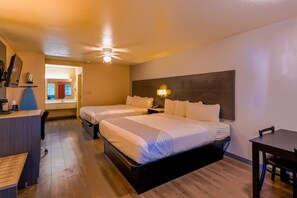 A hotel room with two beds, a desk, a chair, a nightstand, and a ceiling fan. - OYO Hotel Yoakum West (Yoakum)
