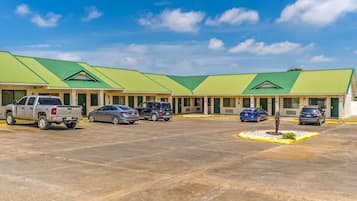 Un motel doté d’un toit végétalisé, de nombreux espaces de stationnement et d’un petit espace paysager agrémenté d’un arbre.
