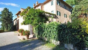 Una casa de piedra de dos plantas con jardín y camino de grava.