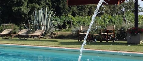 Una piscina al aire libre de temporada, una piscina con cascada