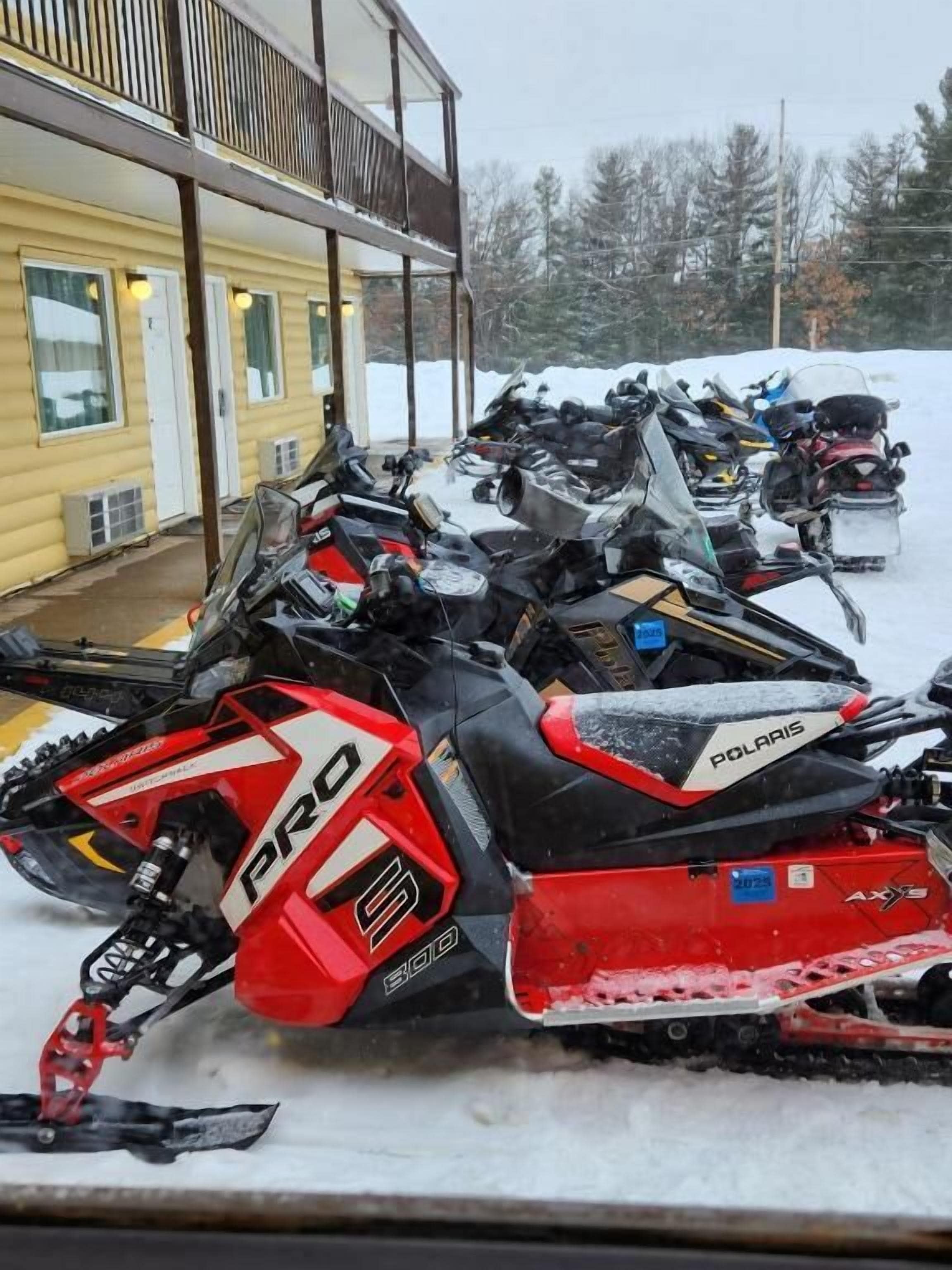 Una moto de nieve estacionada frente a un edificio con balcón.