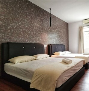 A hotel room with two beds, a dark headboard, a textured wall, a hanging light fixture, and a window with curtains. - Potato Hotel (Taiping)
