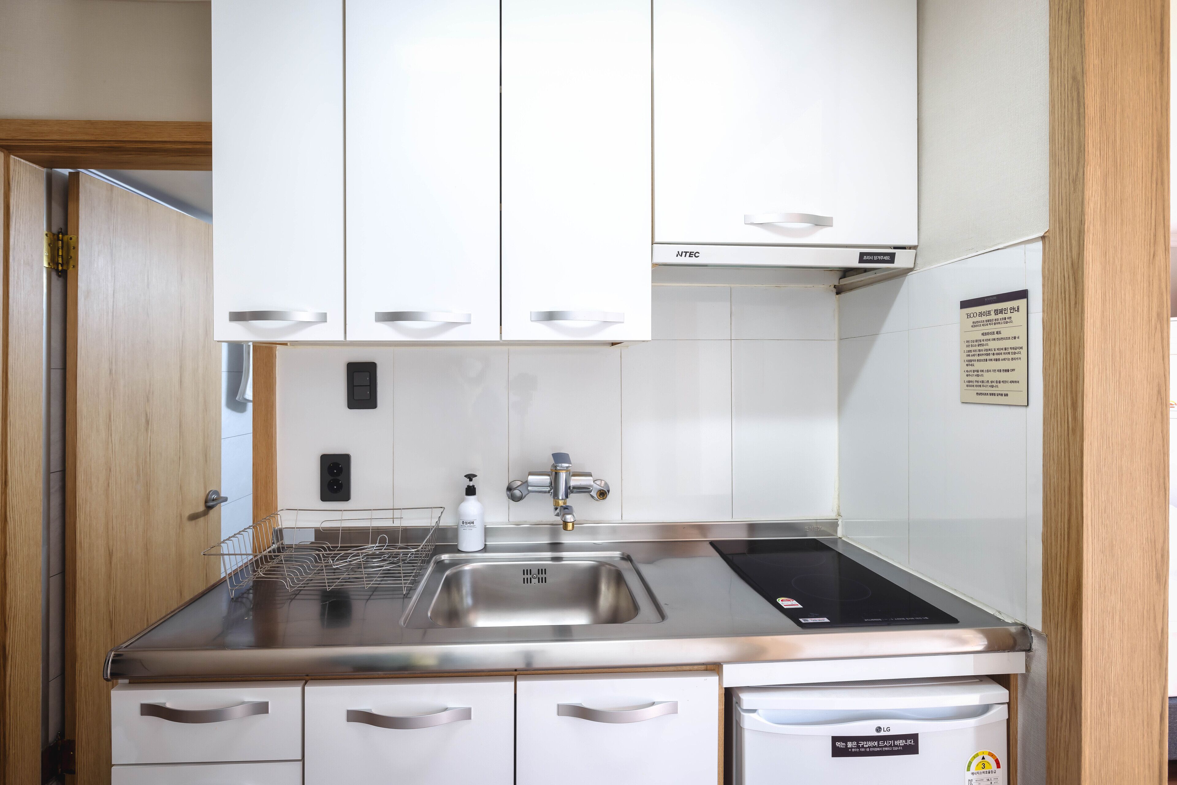 A modern kitchen with stainless steel appliances, white cabinetry, and a built-in dishwasher.