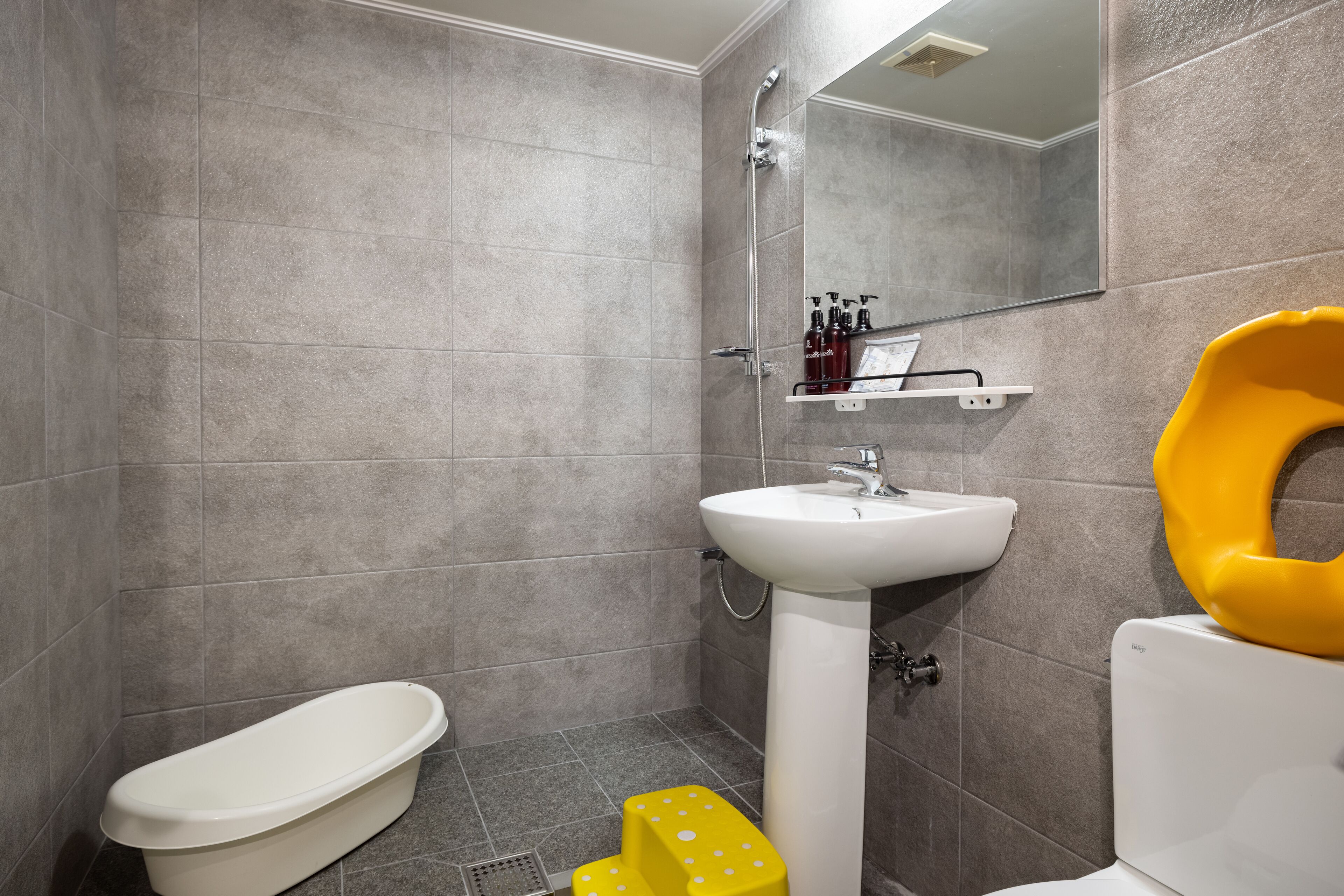 Une salle de bain avec des toilettes, un lavabo et une douche.
