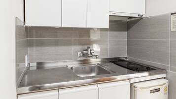 A modern kitchen with stainless steel appliances, a double sink, and white cabinetry.
