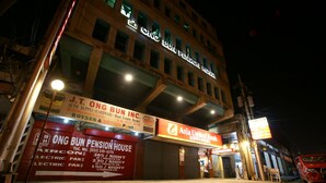 Ein Gebäude mit Schilder für Ong Bun Pension House und Asia United Bank.