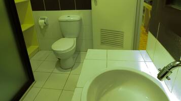 Un baño con inodoro, lavamanos y espejo.