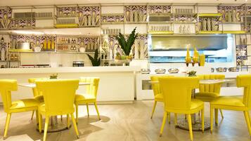 Um restaurante moderno com cadeiras amarelas e uma ilha central.