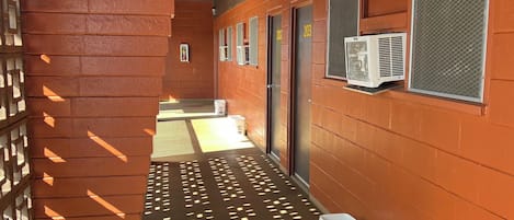 Ein Flur mit einer Backsteinwand und an der Wand befestigten Klimaanlagen.