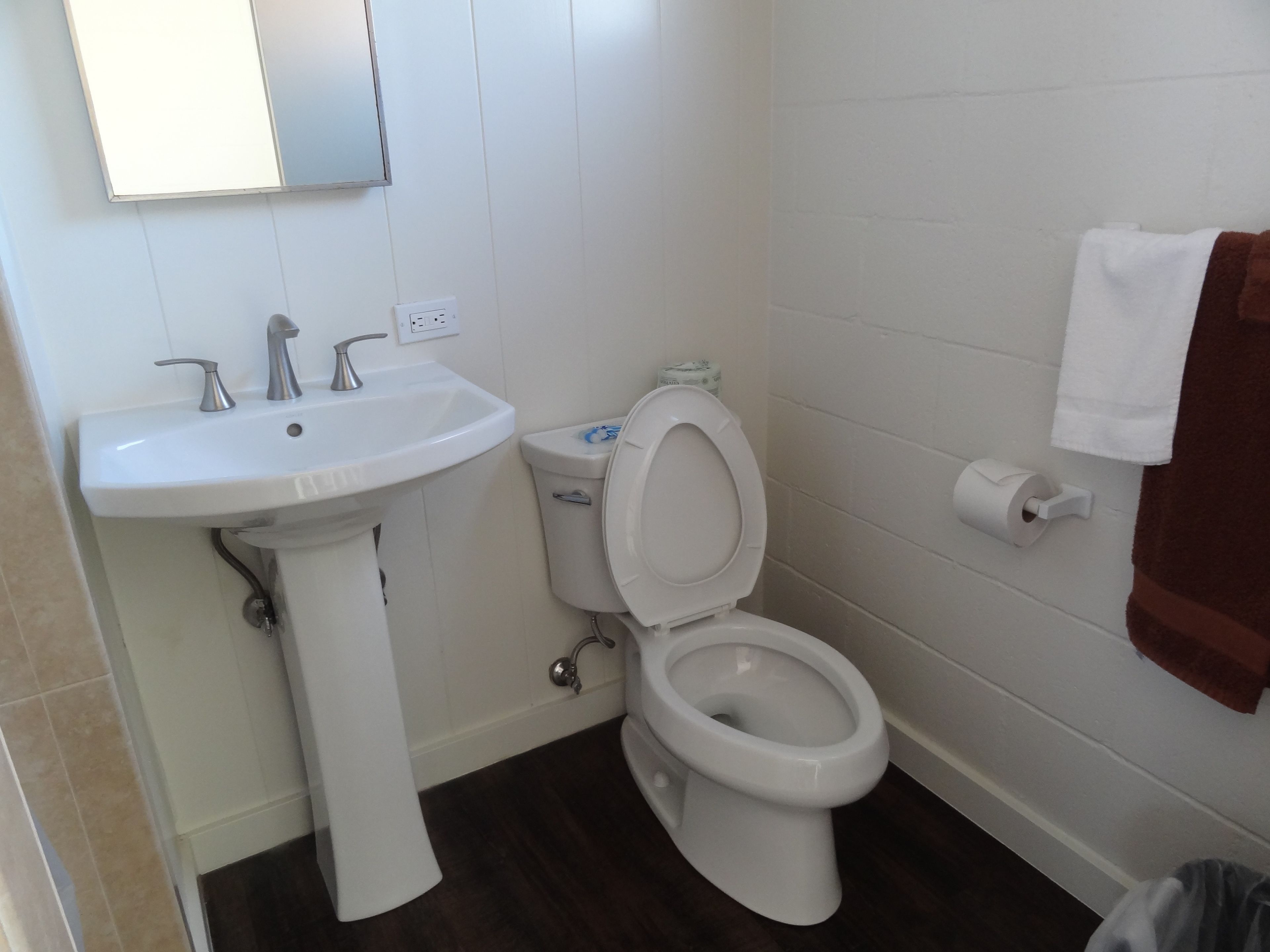 Ein Badezimmer mit Waschbecken, Toilette und Spiegel.