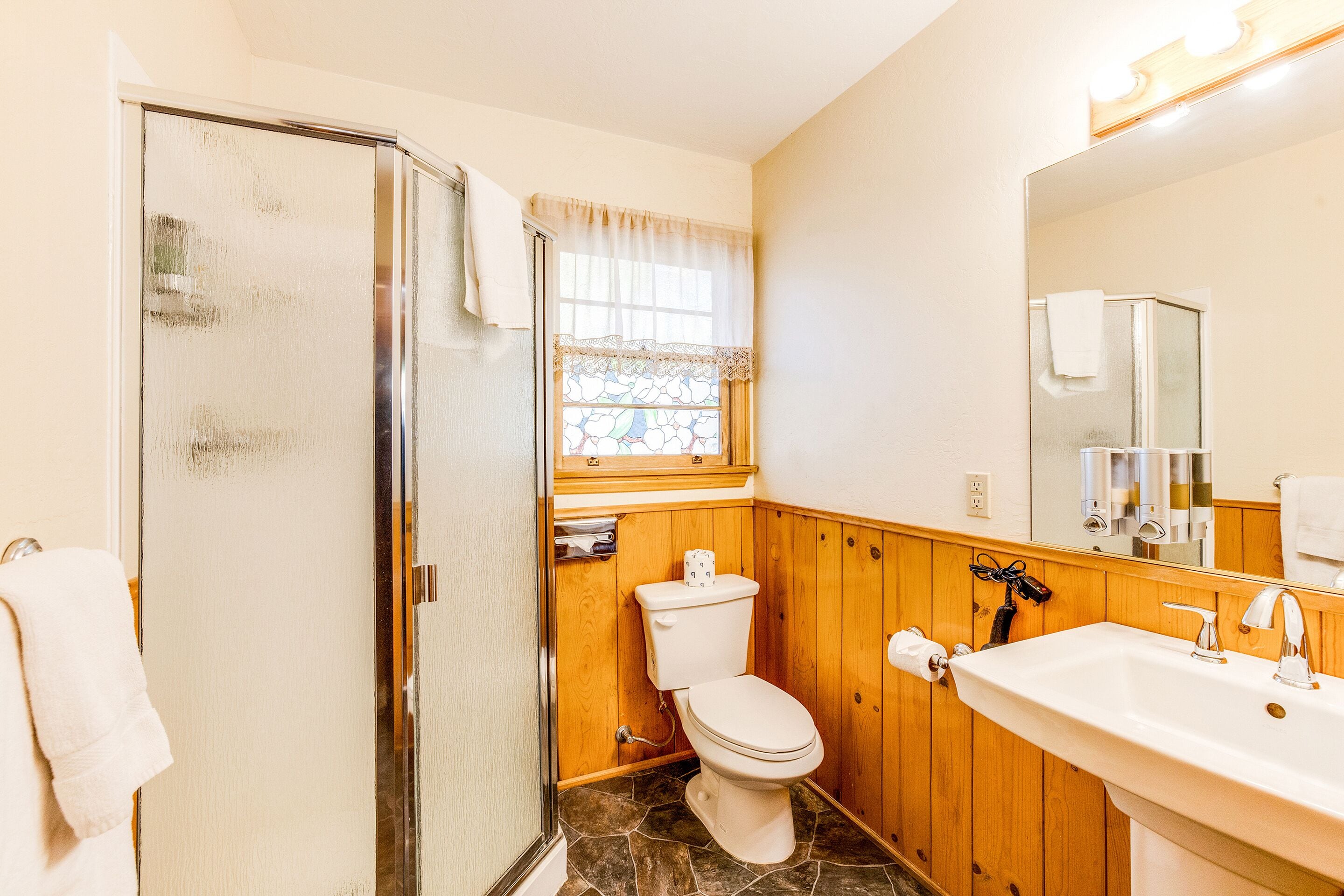 A bathroom with a shower, toilet, and sink.