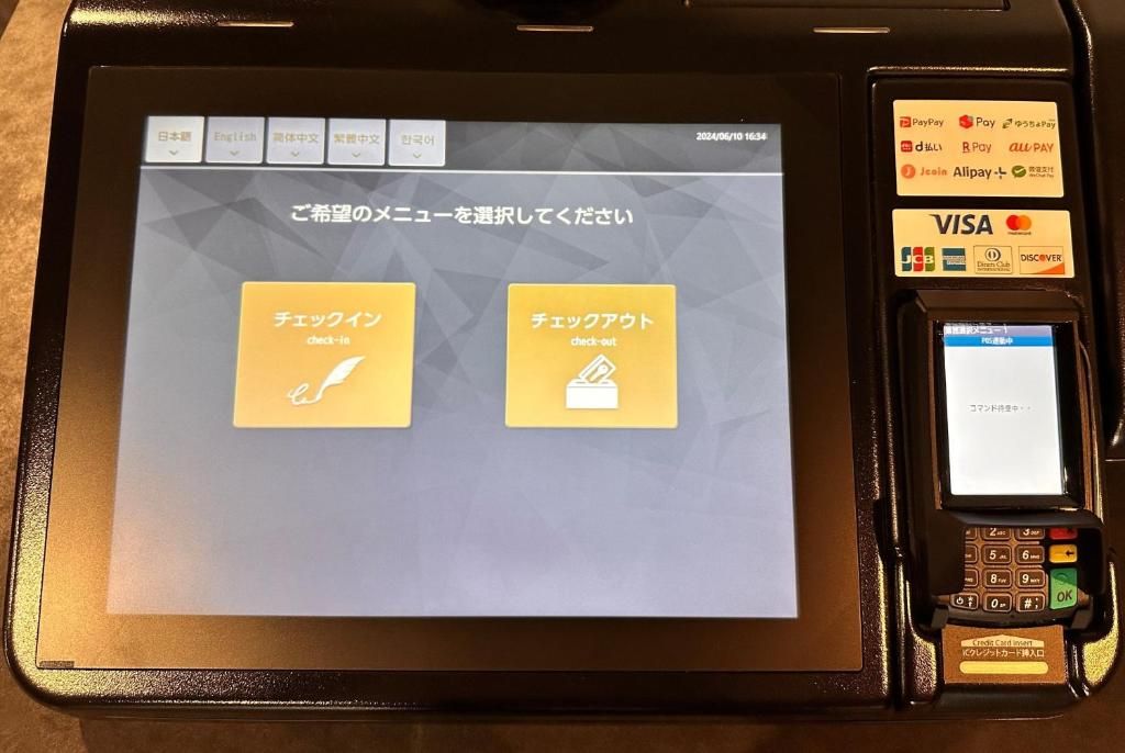 Un terminal de pago con pantalla que muestra opciones de registro de entrada y salida.