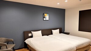 Una habitación de hotel moderna con una cama grande, una silla y un cuadro en la pared.