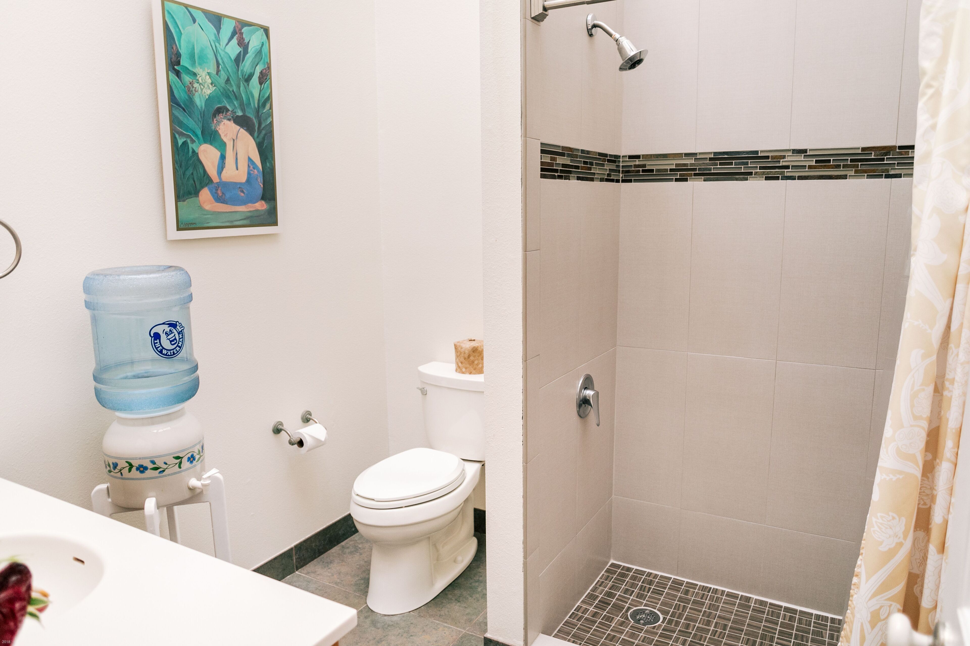 Un baño con inodoro, dispensador de agua, ducha y lavabo.