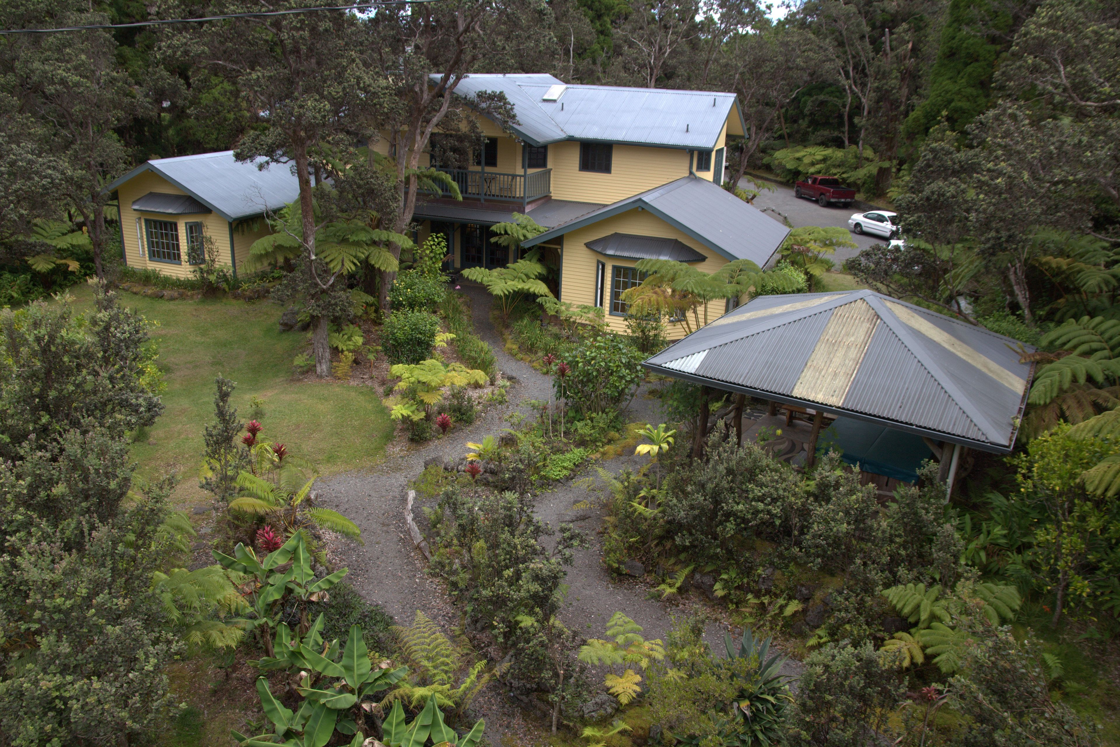 A two-story house with a large garden, a covered porch, and a garage.