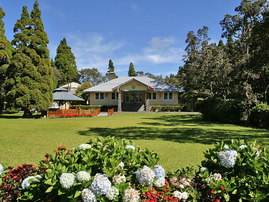 A large house with a lawn and garden in front.