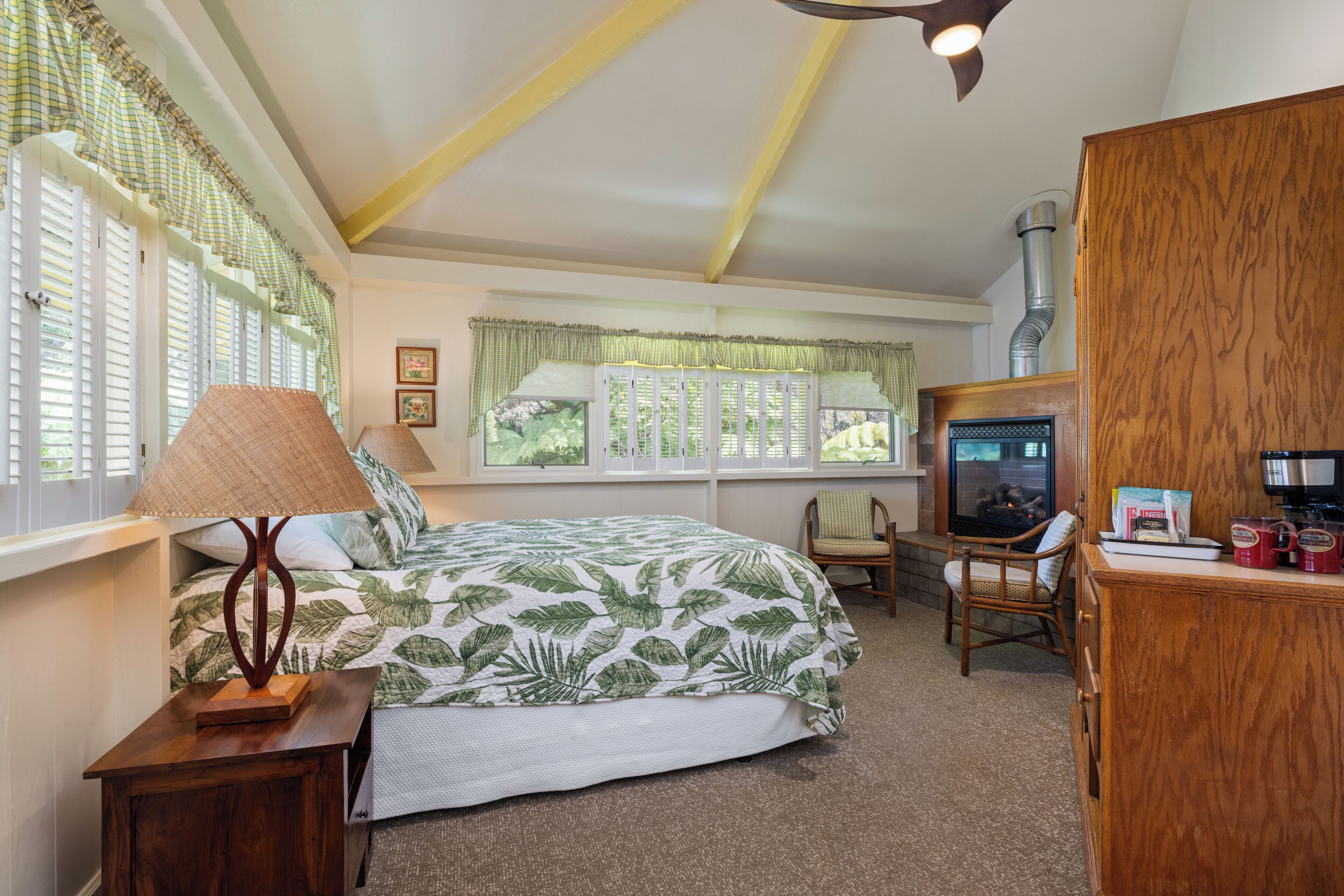 A bedroom with a bed, a wooden nightstand, a chair, a television, and a cabinet.