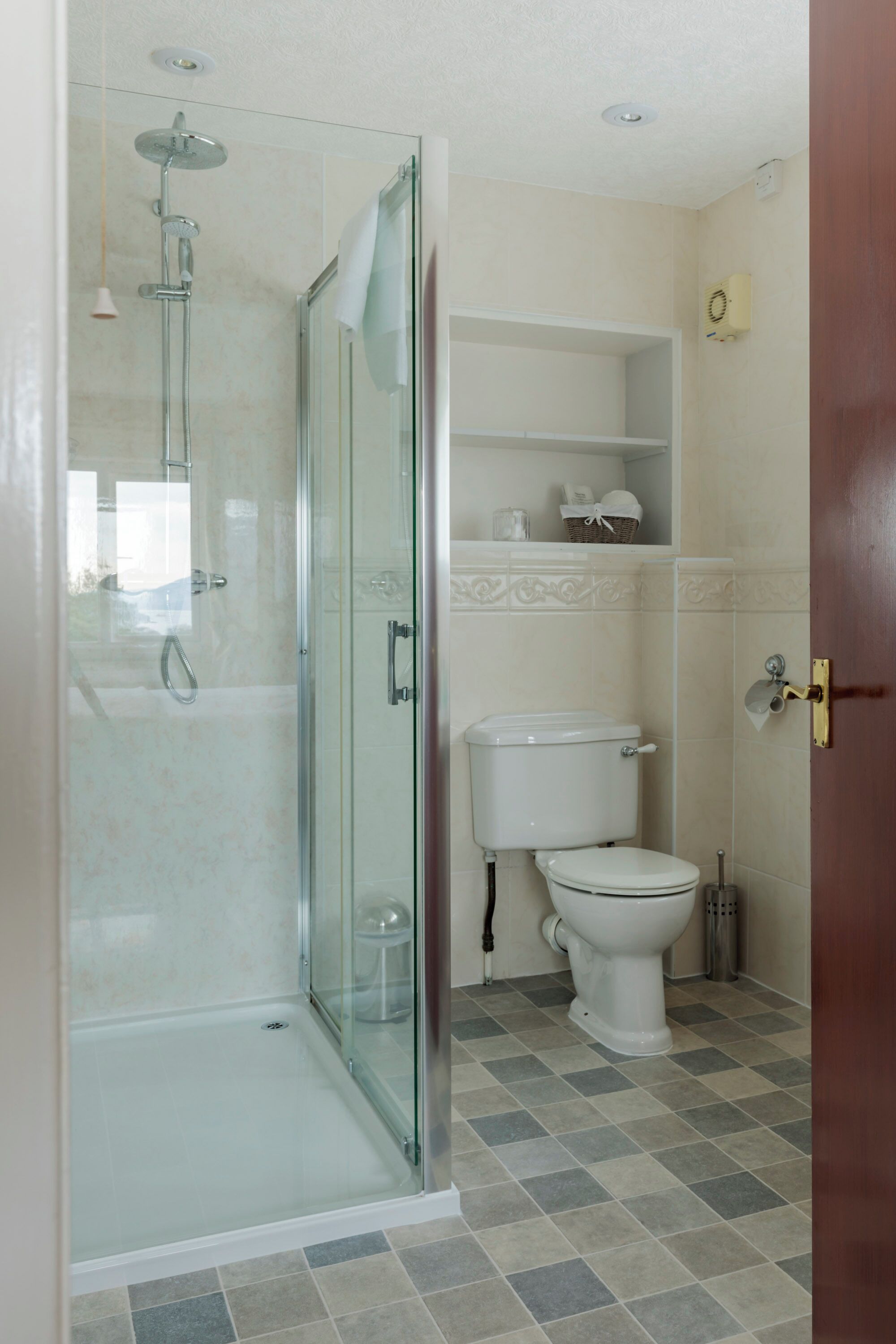 Une salle de bain avec une douche à parois de verre, des toilettes et un lavabo.