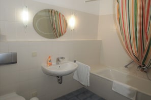 A bathroom with a sink, mirror, and bathtub. - Backpacker Hostel Bremen (Bremen)
