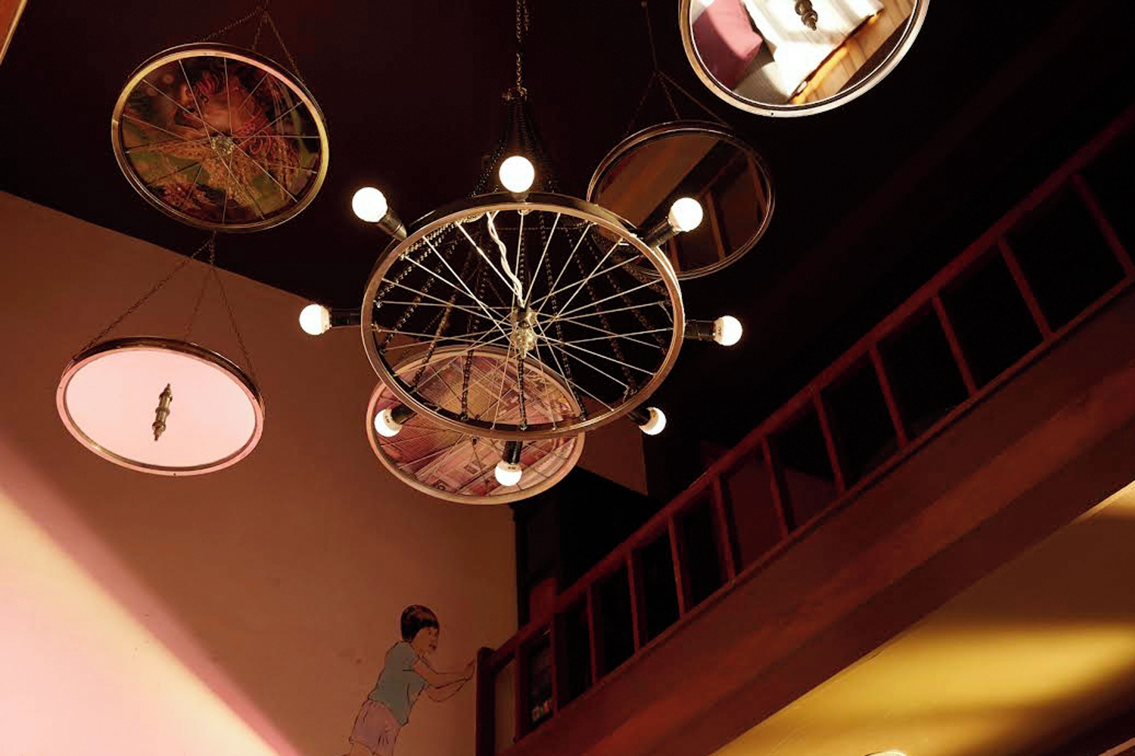 A chandelier with multiple circular mirrors and lights in a dimly lit room.