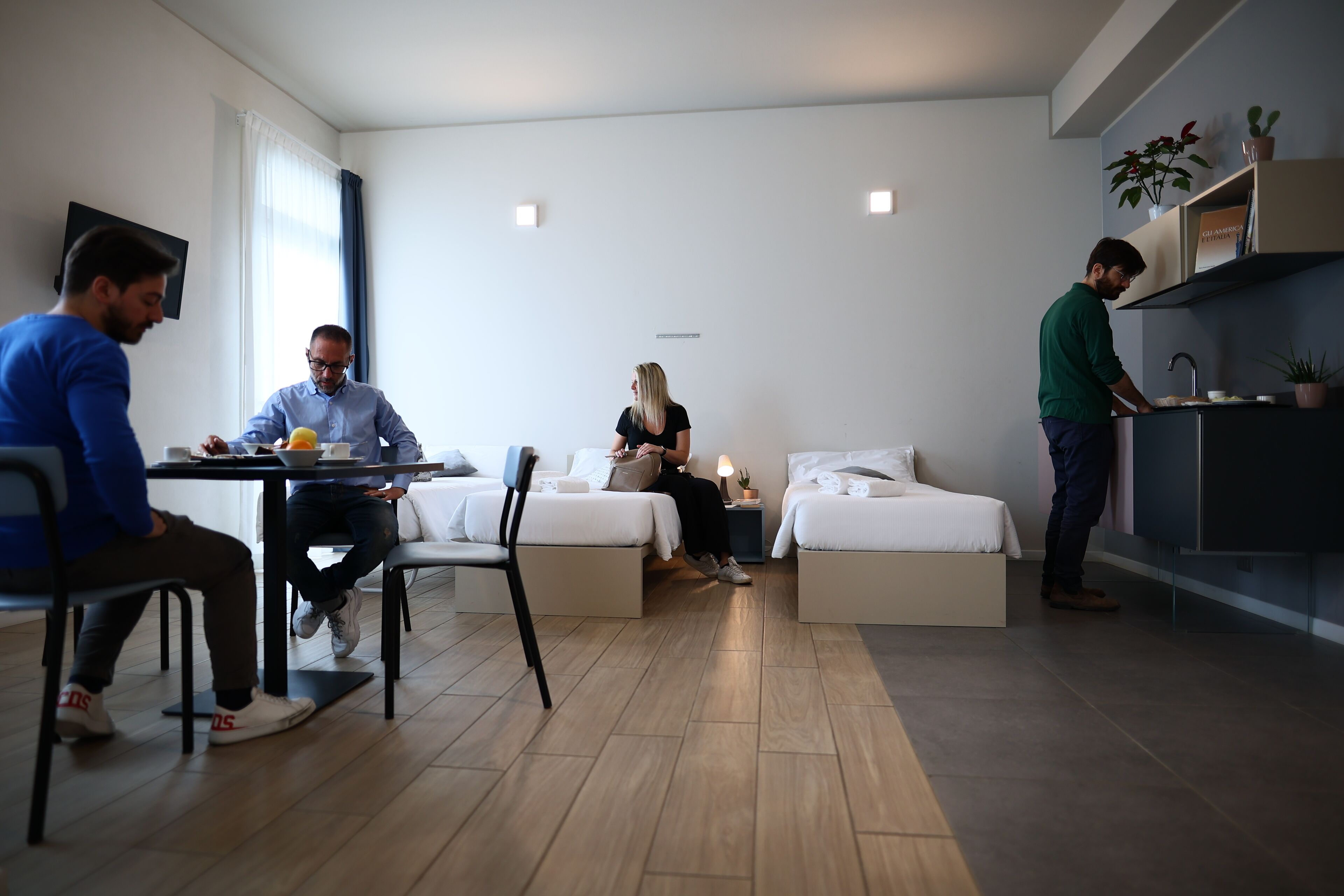 Una habitación moderna y bien iluminada con comedor, sofá y cama.