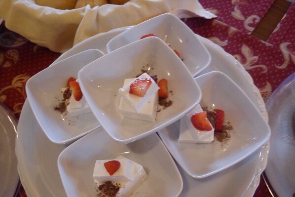 Una bandeja de cubos de postre con fresas sobre una mesa.