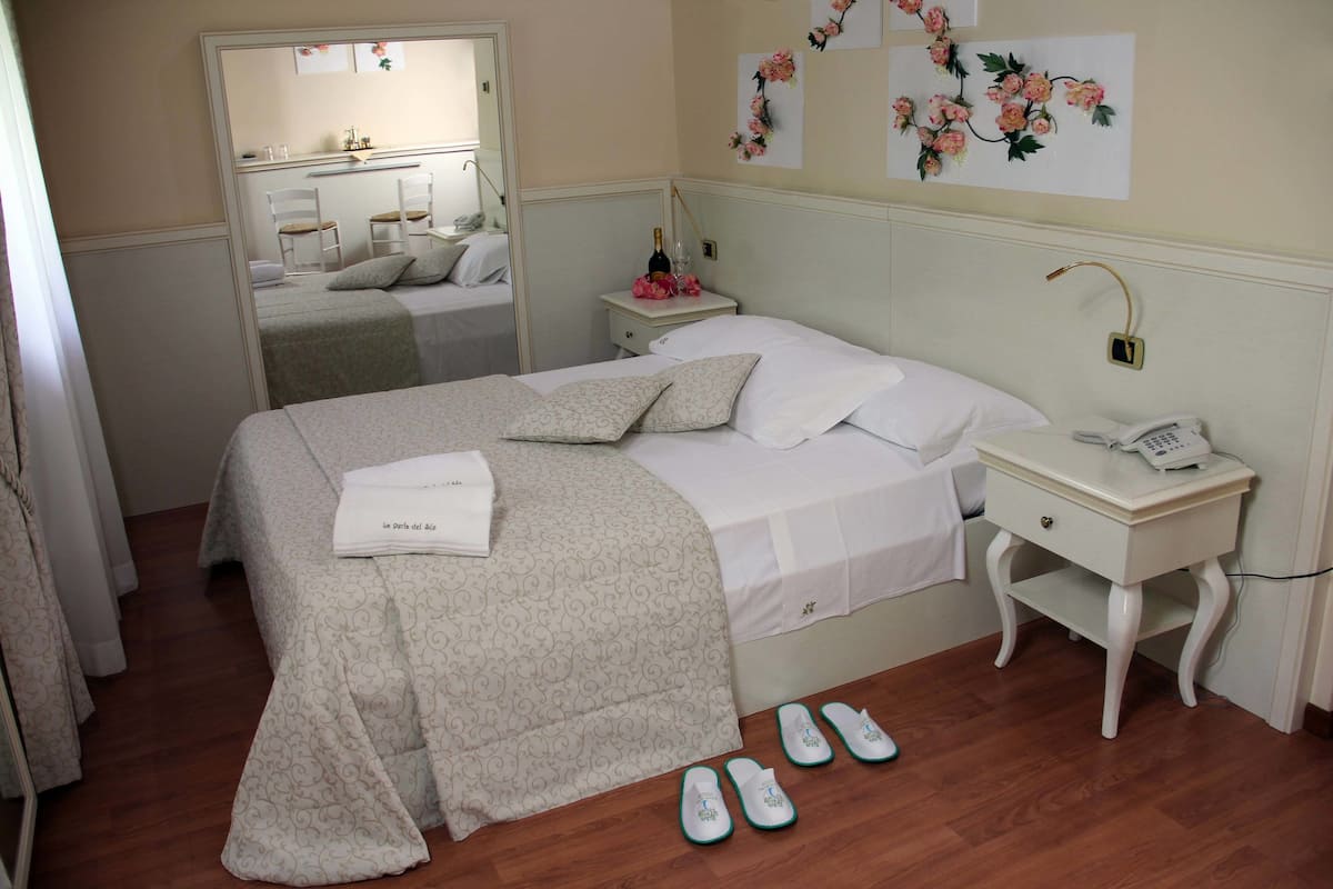 Ein ordentlich eingerichtetes Schlafzimmer mit Bett, Nachttisch und Spiegel.
