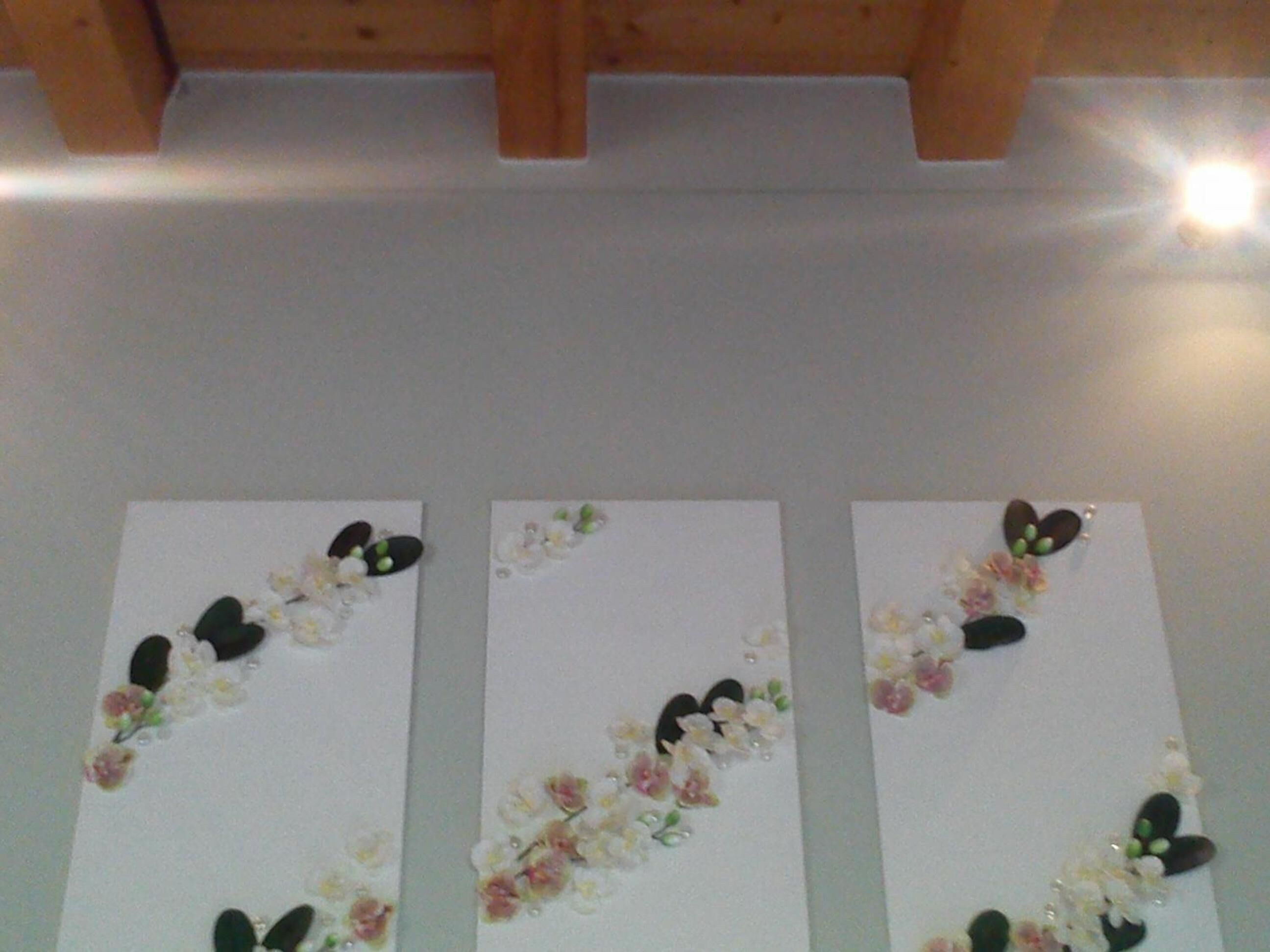 Three white panels with floral and leaf decorations.