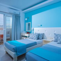 Habitación de hotel con dos camas, un balcón y vistas.