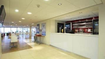 A spacious lobby with a reception desk, seating area, and a display of products.