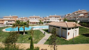 Un quartier résidentiel composé de plusieurs maisons à deux étages, d’une piscine et d’un petit bâtiment doté d’un toit en tuiles.