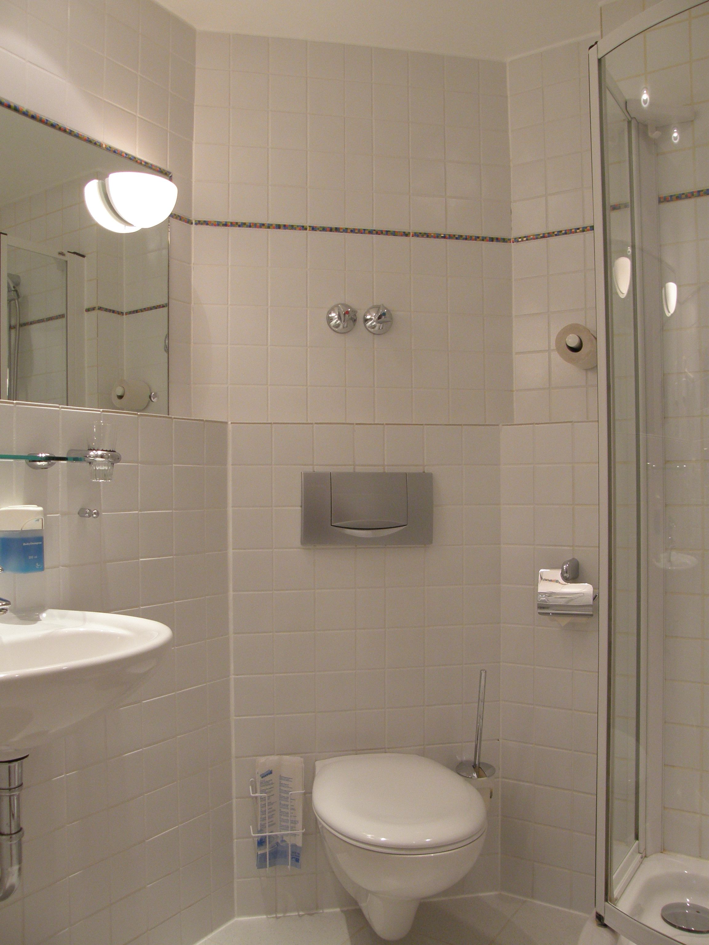 Un baño con lavamanos, inodoro y ducha.