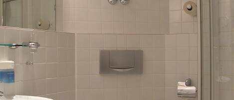 Un baño con lavamanos, inodoro y ducha.