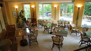 A restaurant with multiple tables and chairs, large windows, and indoor lighting. - St.-Michaels-Heim Hotel (Berlin)