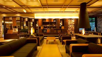 A modern interior with sofas, tables, and a fireplace.