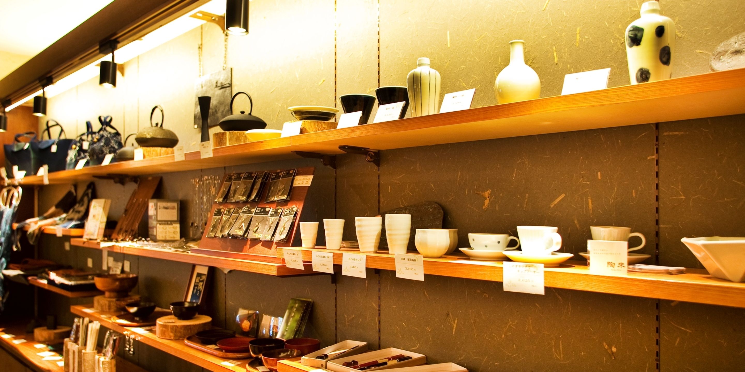 Shelves with various ceramic items, including cups, bowls, and vases, with price tags.