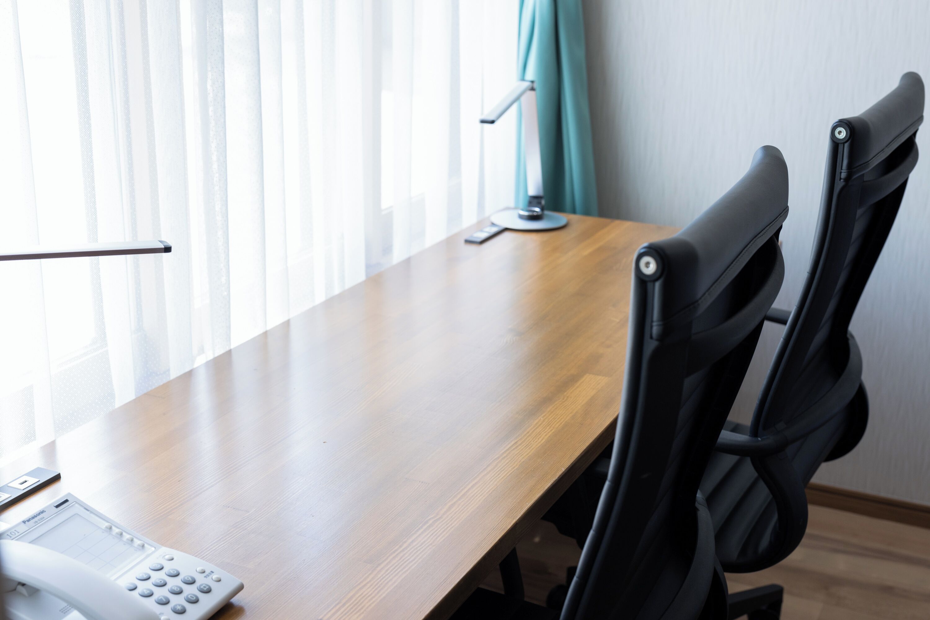 Une table de conférence avec un téléphone et une lampe.