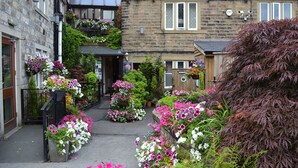 A narrow street with stone buildings, flower boxes, and a wooden fence. - The Old Bell Inn (Oldham)