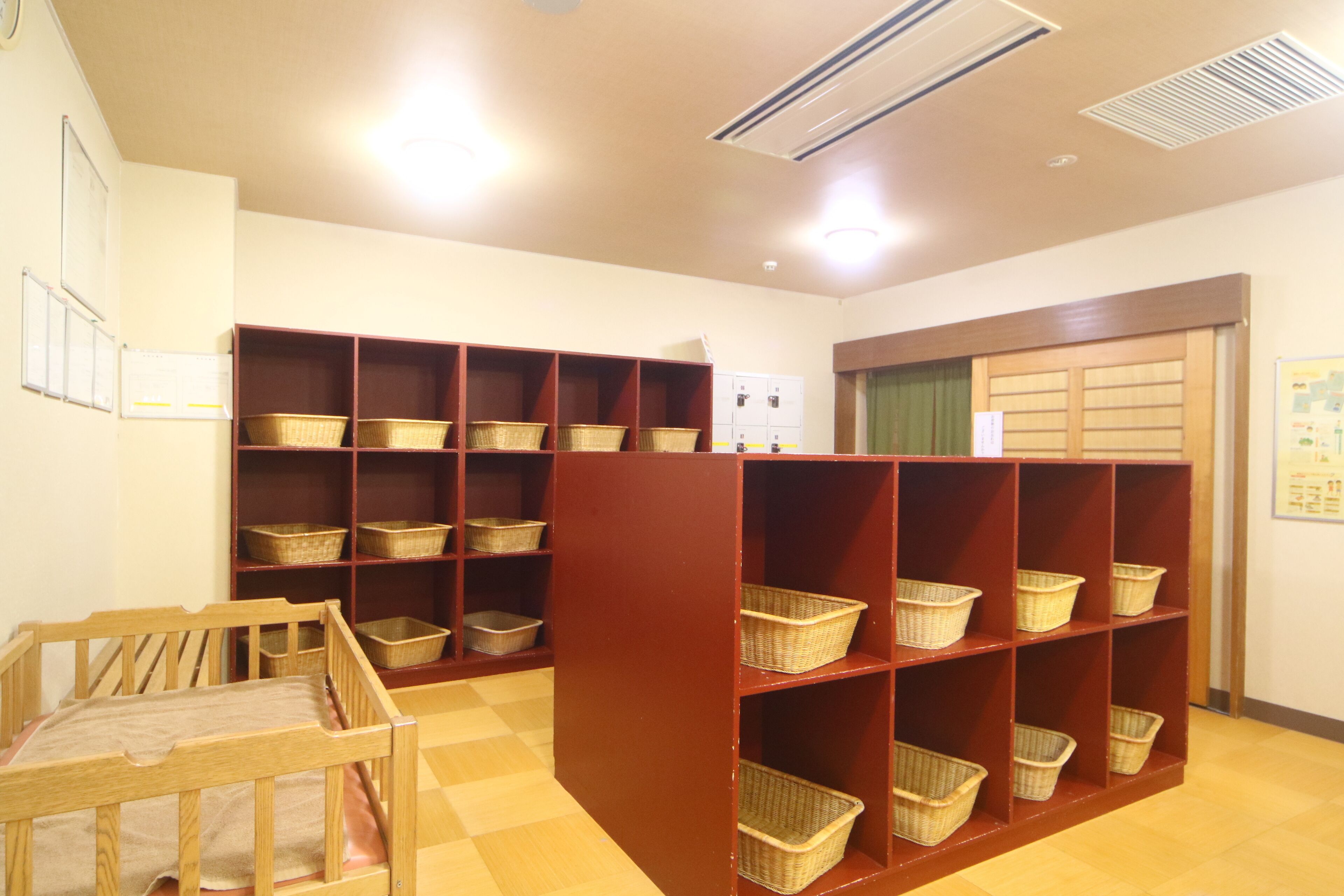 Una habitación con muebles de madera, incluyendo una cuna y una estantería llena de cestas.