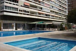 A multi-story hotel with a swimming pool in the foreground. - Cervantes (Benidorm)