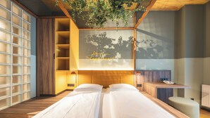 Una habitación de hotel moderna con una cama grande, un escritorio pequeño y un televisor montado en la pared.