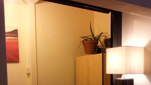 Un comptoir d’accueil d’hôtel agrémenté d’une plante en pot, d’une lampe et d’un miroir.