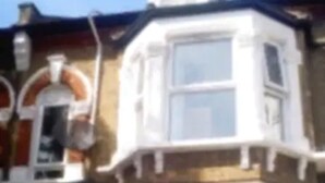 Une maison d’angle avec une baie vitrée et un lucarne.