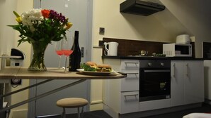 Une cuisine équipée d’un four à micro-ondes, d’un four traditionnel et d’un coin repas avec une table et des chaises.