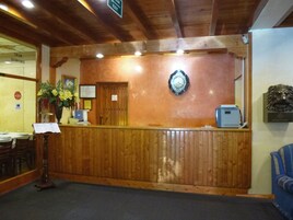 A wooden reception desk with a no entry sign, a clock, and a lion head decoration.