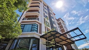 Un edificio de varios pisos con balcones, ventanas amplias y cielo despejado.