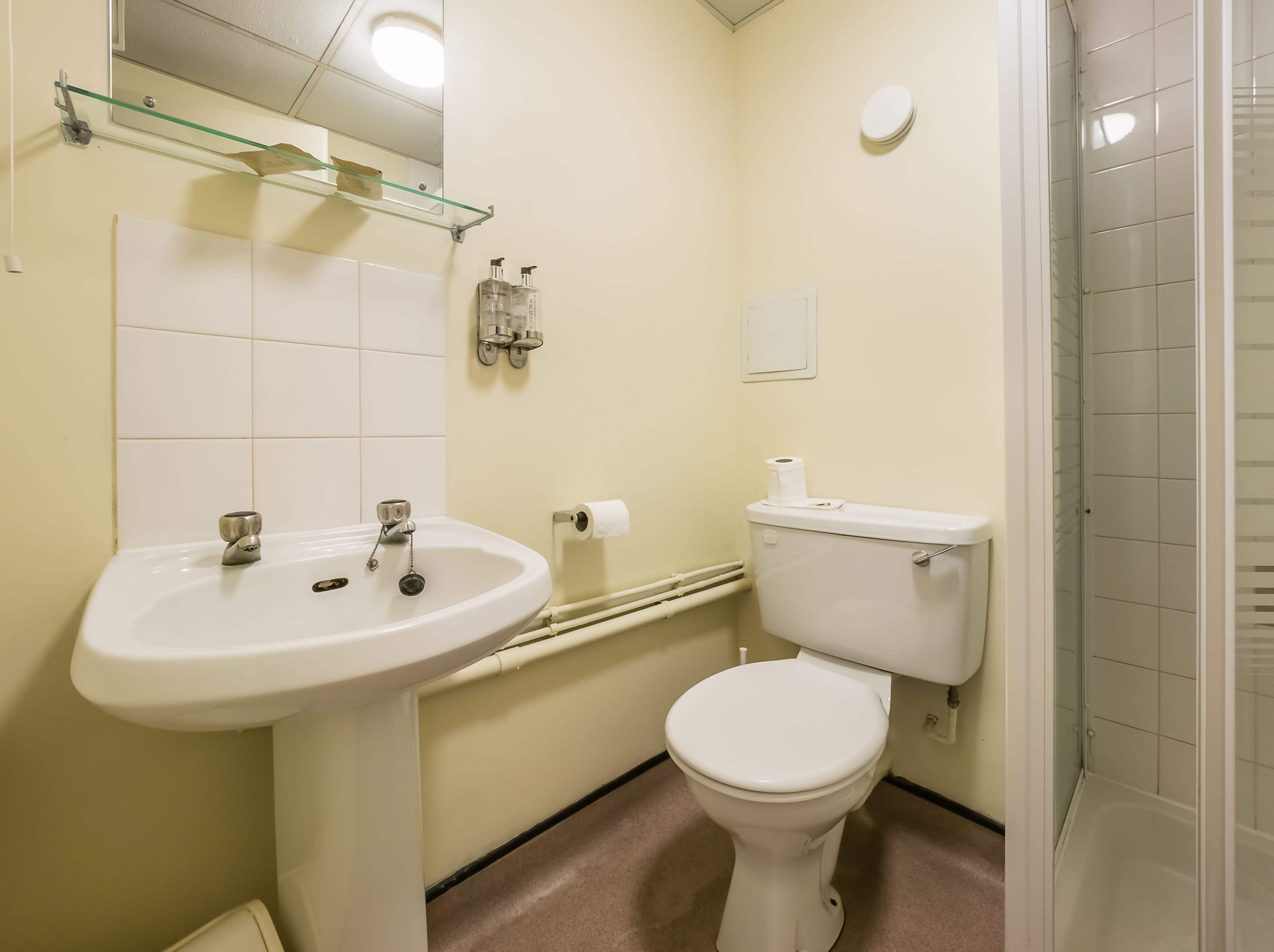 A bathroom with a white sink, toilet, and shower.