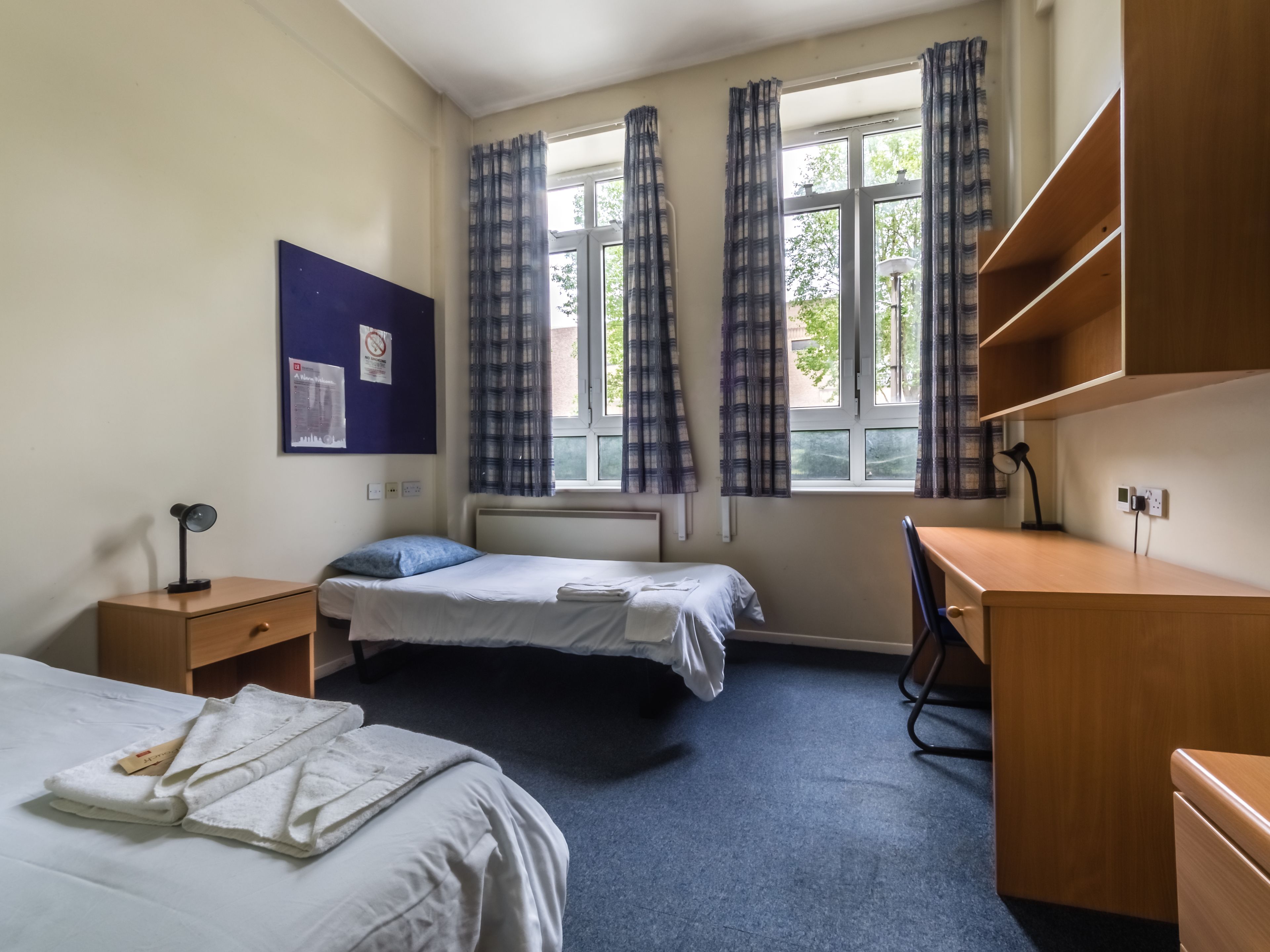 Une chambre avec deux lits, un bureau et une chaise.