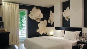 Un dormitorio moderno con una cama grande, una mesita de noche, un escritorio y una ventana con cortinas.