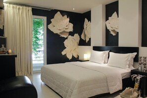 Quarto moderno com cama grande, mesa de cabeceira, escrivaninha e janela com cortinas.